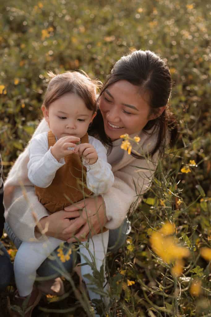 Mor og barn nyter sesongens blomster i høstlandskapet.