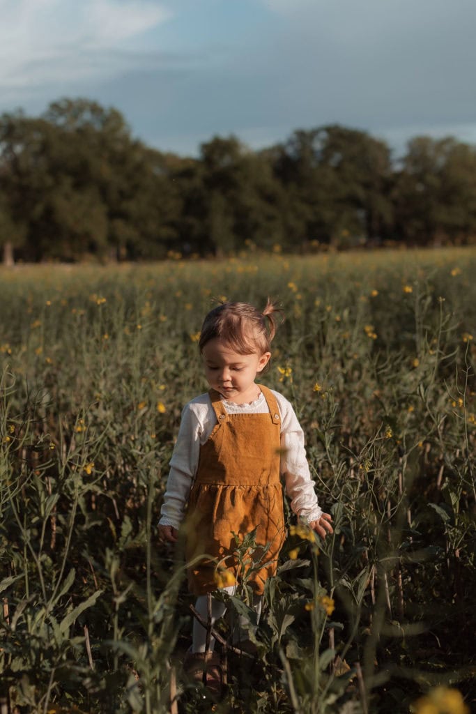Barn som utforsker blomster i en blomstereng om våren.