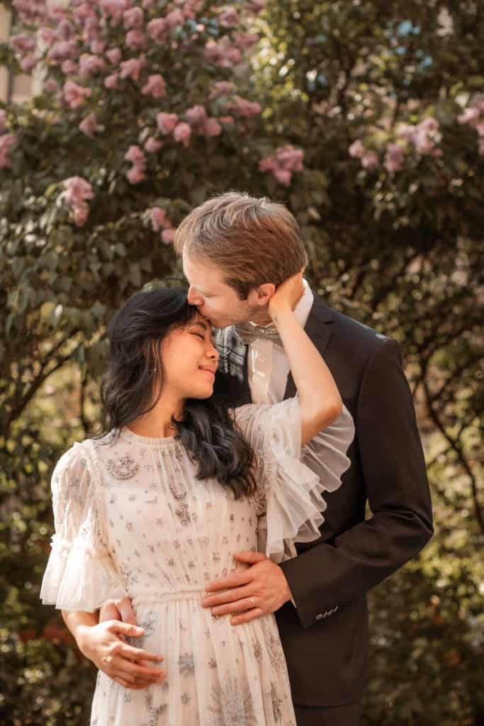 Par i blomsterhage med sesongens blomster og romantisk stemning.