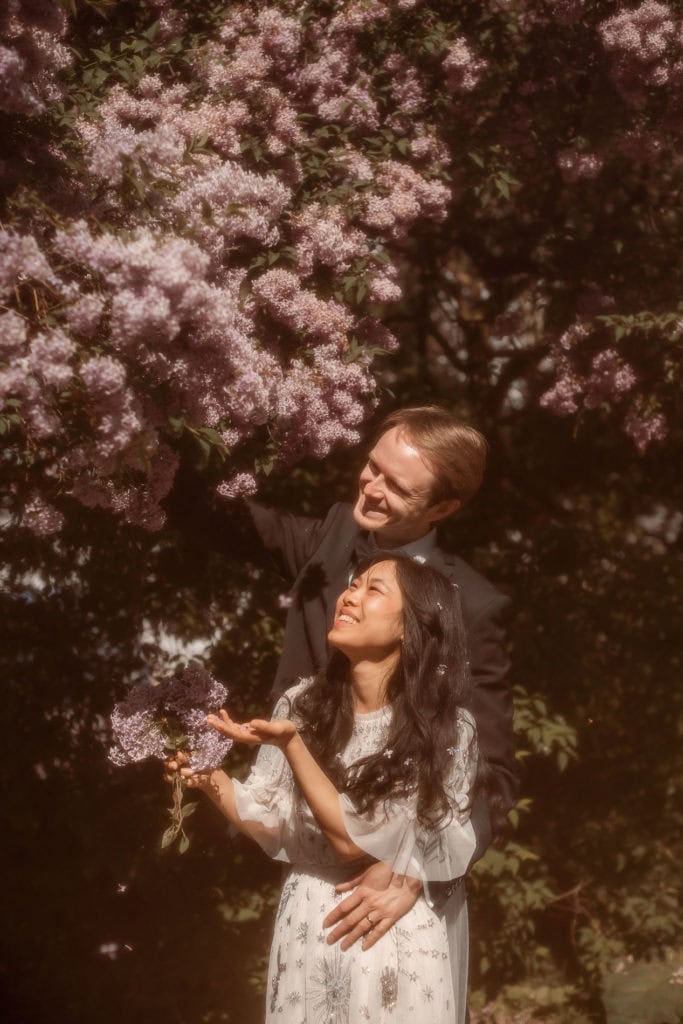 Par nyter sesongens blomster i en blomsterhage om våren.