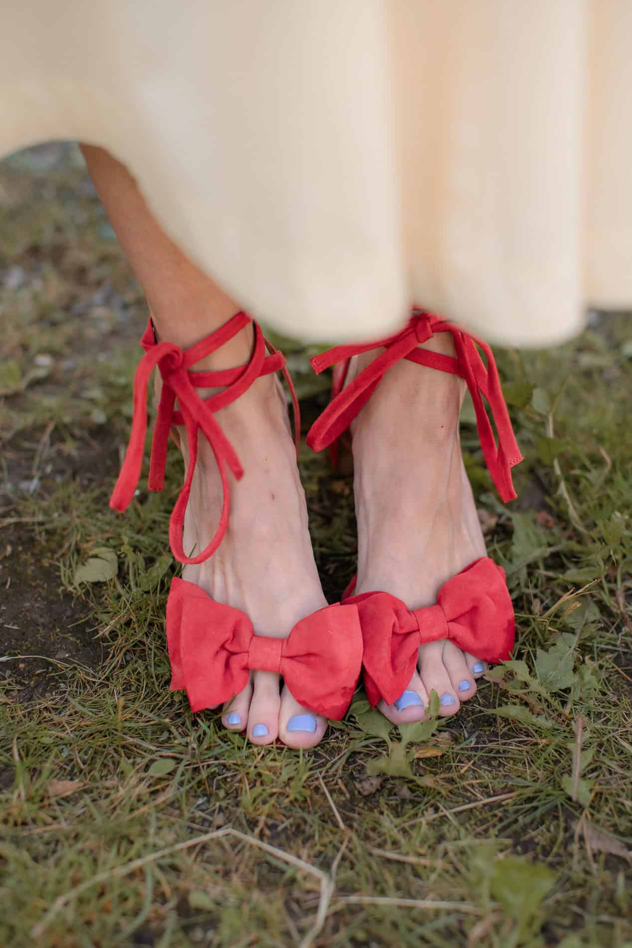 Høye hæler med røde sløyfer og bue, utendørs.
