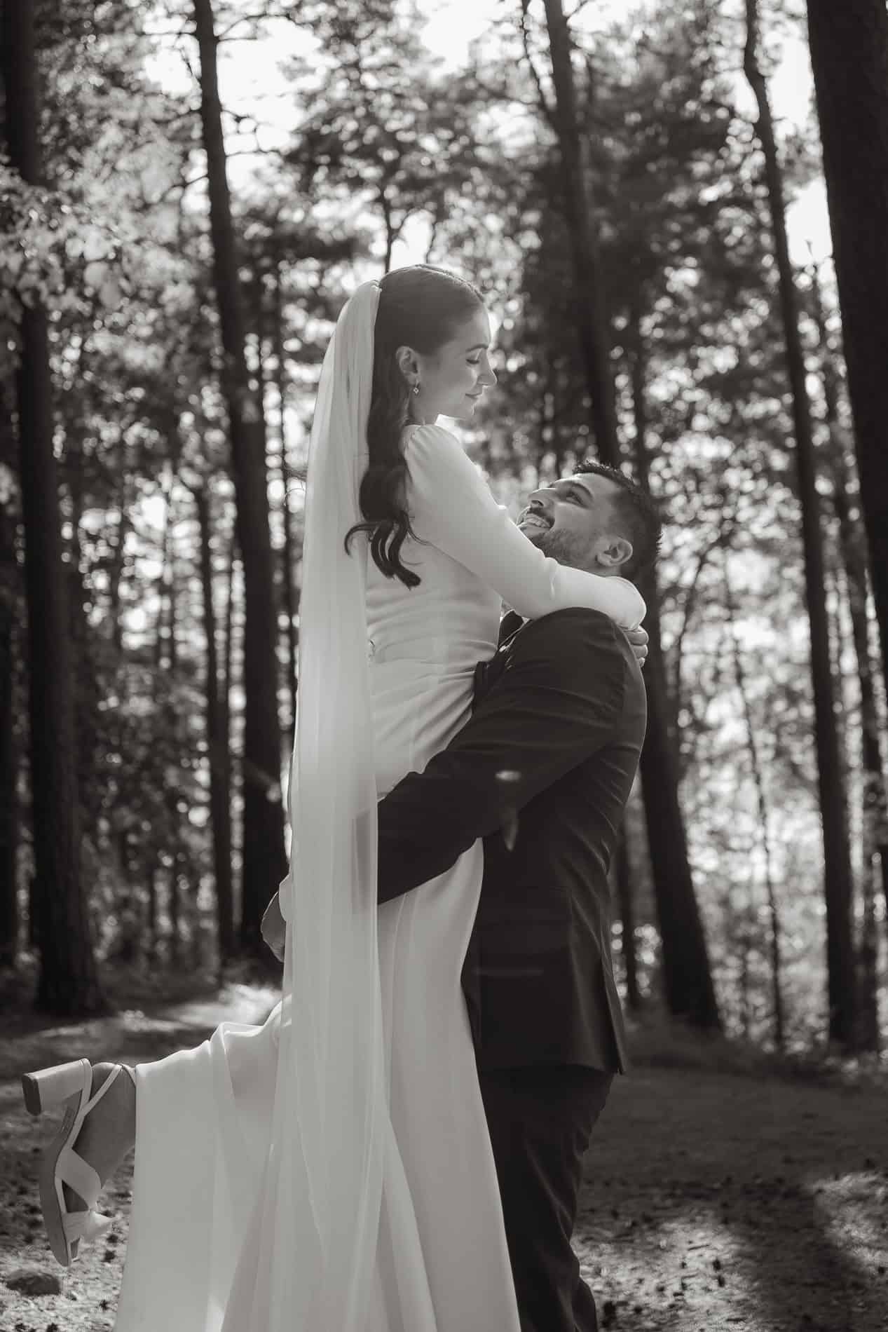 Bryllupsfoto av et lykkelig par i skogen, med naturen som bakgrunn.