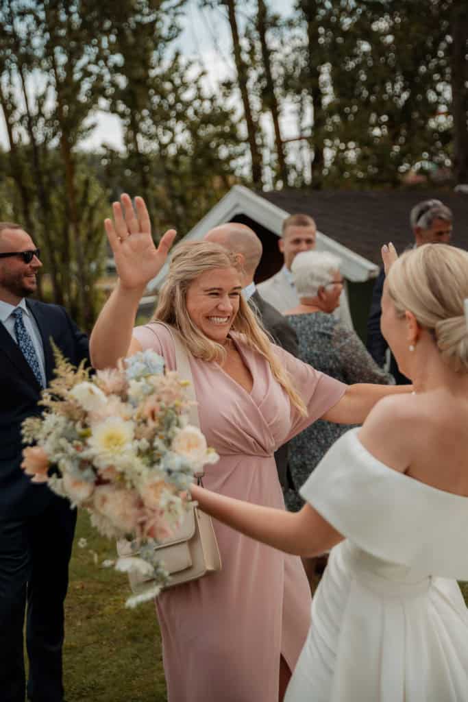 Stemningsfull bryllupsfeiring med smilende gjester og vakker dekorasjon.