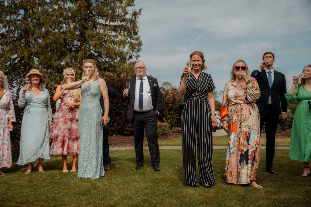 Feststemning under bryllupet med glade gjester i vakre klær.