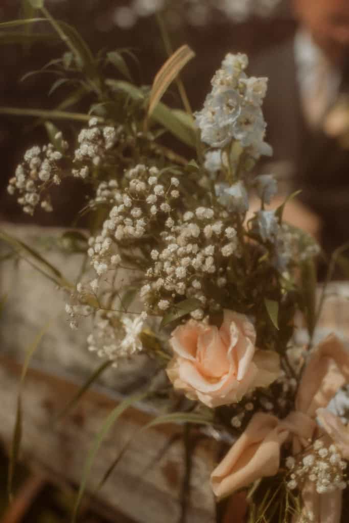 Nydelig blomsteroppsats med roser og villblomster under bryllupet.