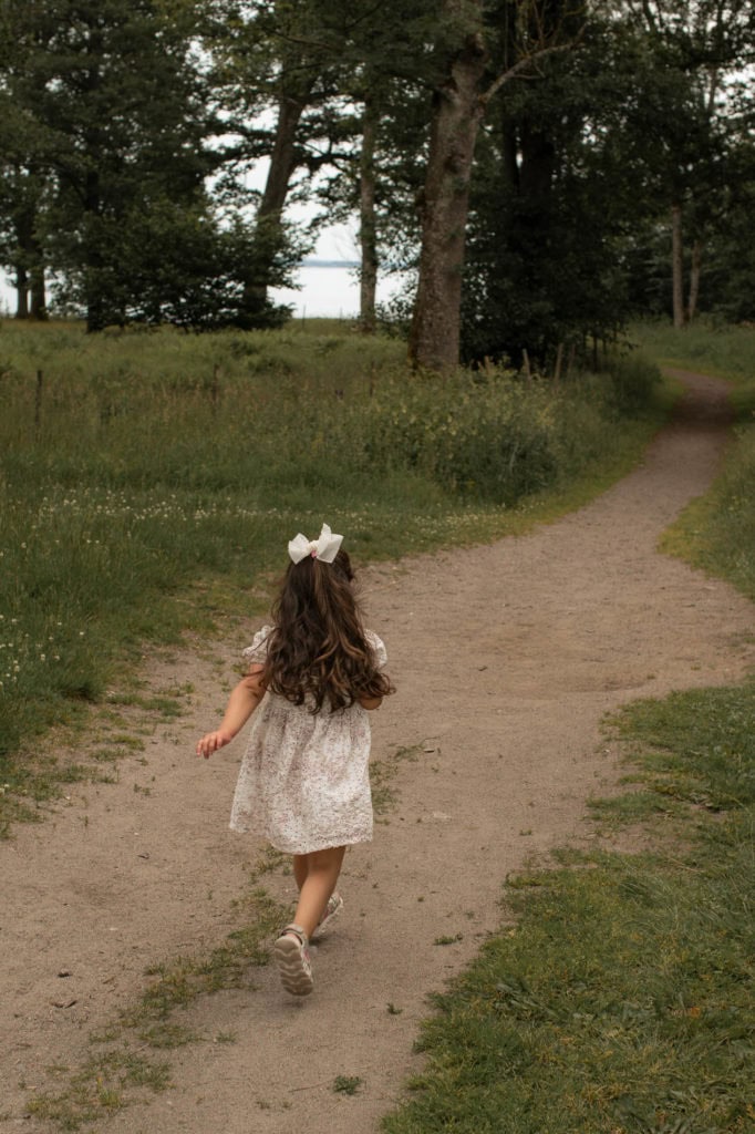Barn som går tur i skogen, natur og barneglede.