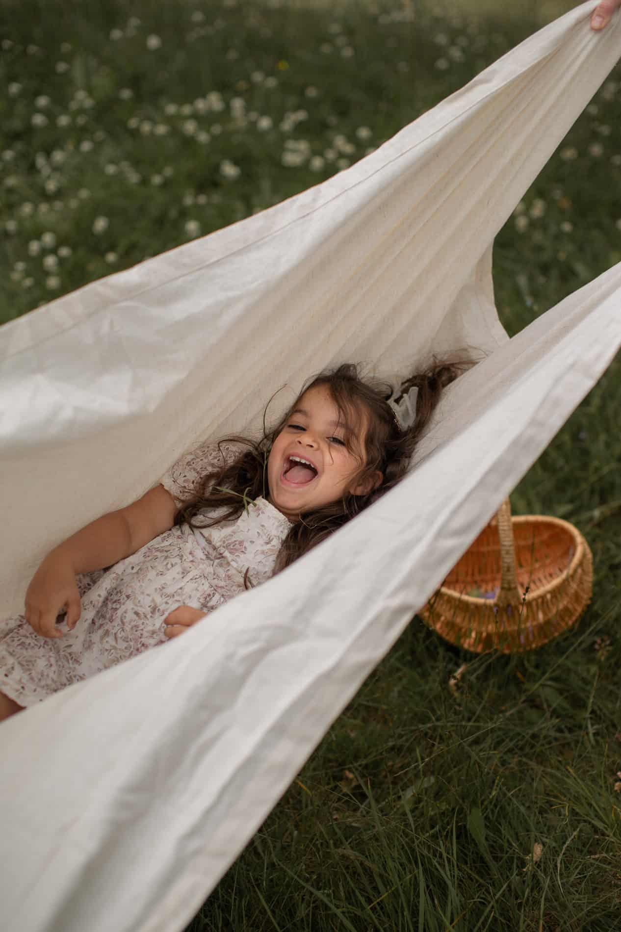 Barn som koser seg i utendørs hengekøye.