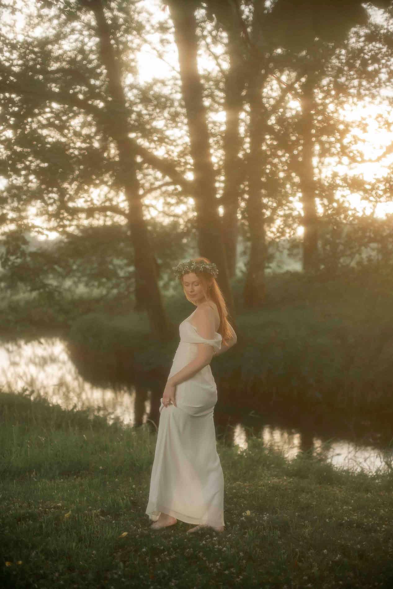 Vakker kvinne i en rolig naturinnstilling ved solnedgang.