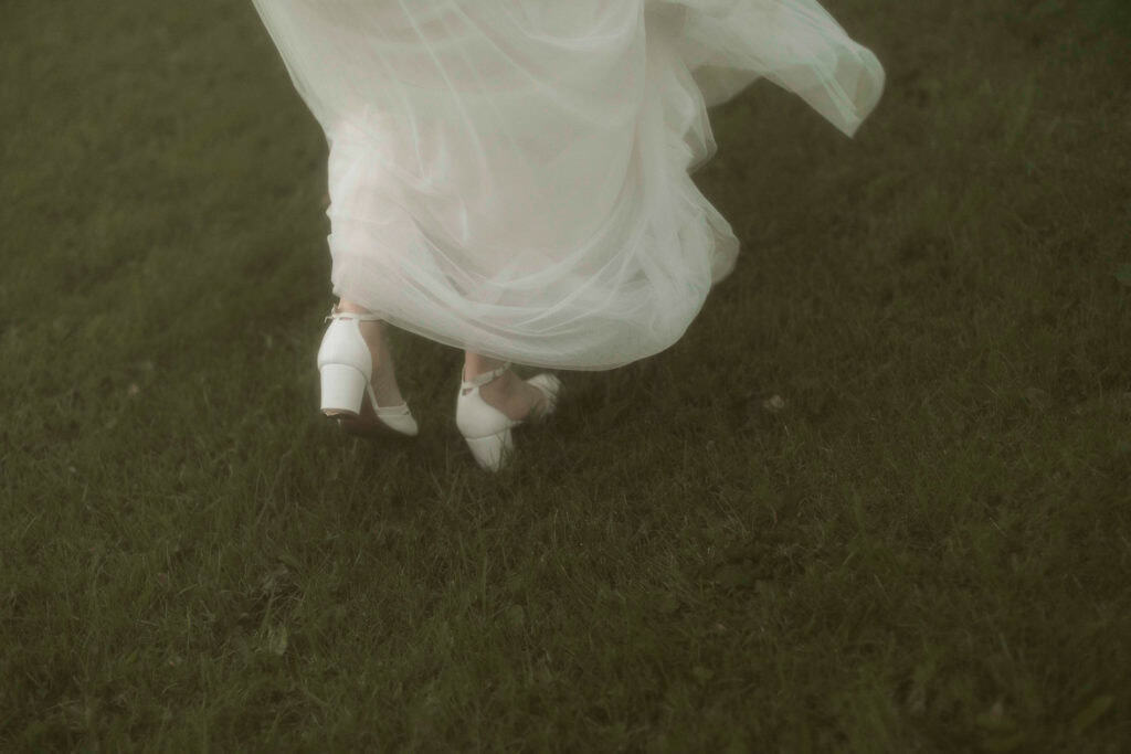 Bryllupskjole og sko på grønt gress.