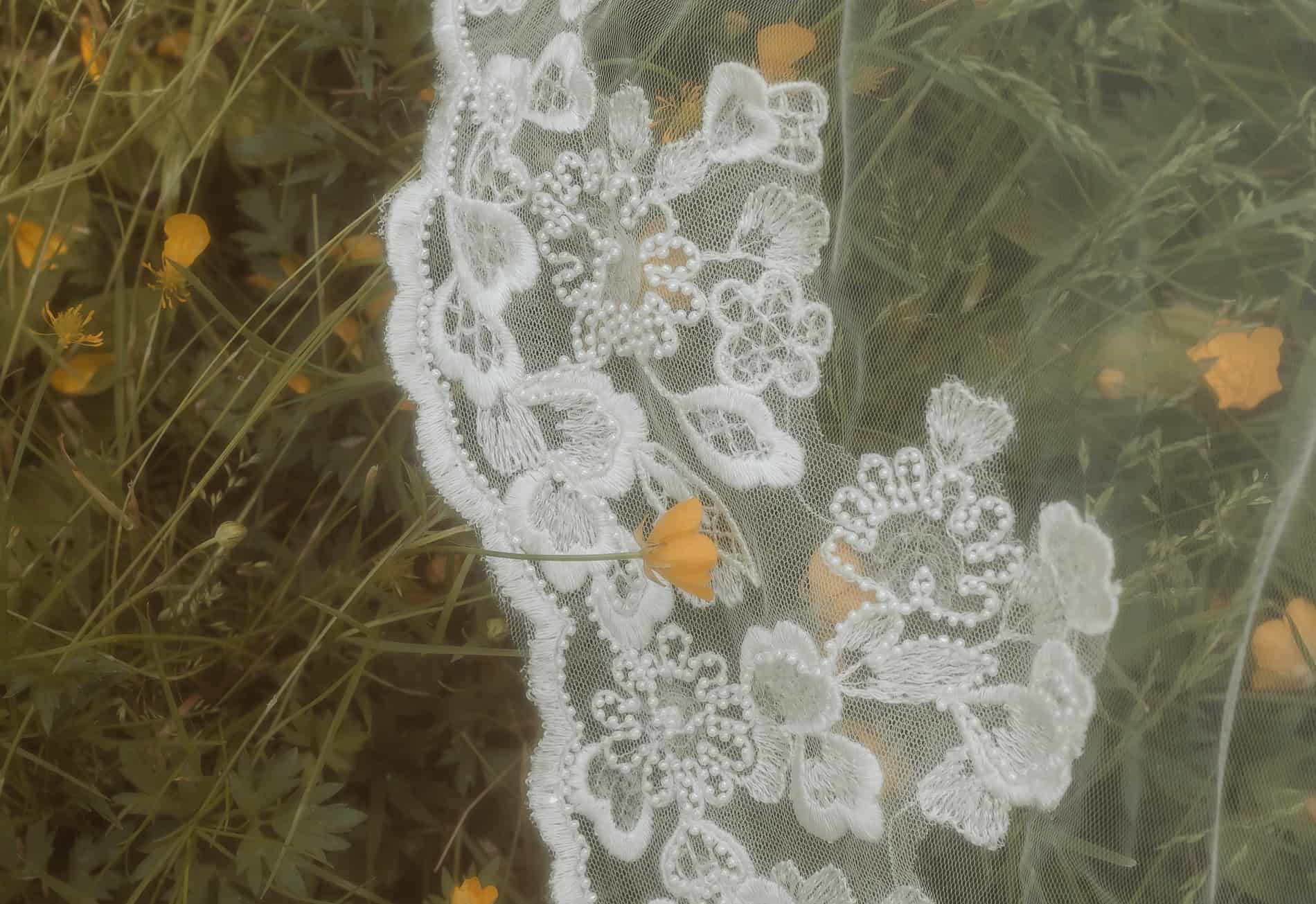 Nærbilde av blondeløper med blomsterdetaljer for bryllupsfotografering i Oslo.